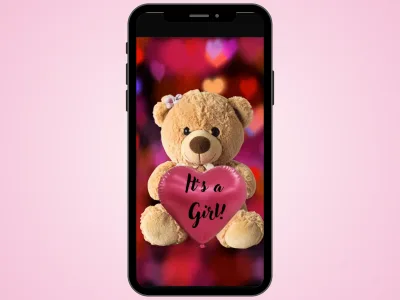 Teddy bear gender reveal scratch card on a phone over a soft pink background, heart scratched to reveal It's a Girl